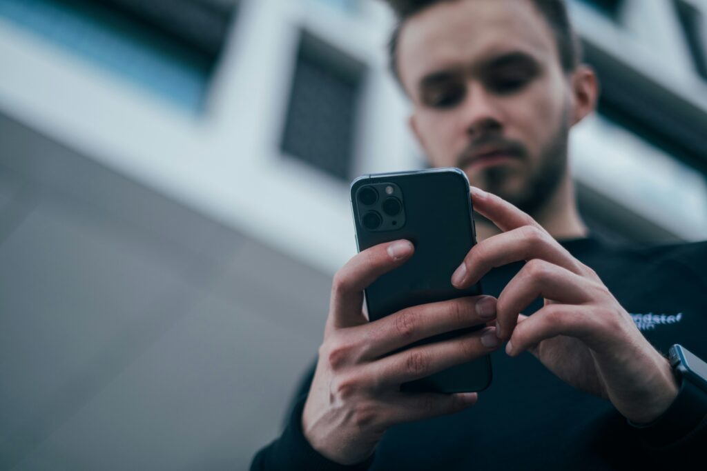 Jauni žmonės naudojasi išmaniuoju telefonu – iliustracinė nuotrauka