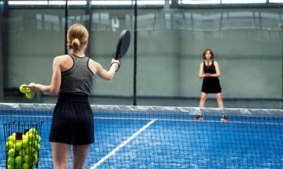 Padelį žaidžiantys žmonės sporto aikštelėje