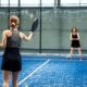 Padelį žaidžiantys žmonės sporto aikštelėje
